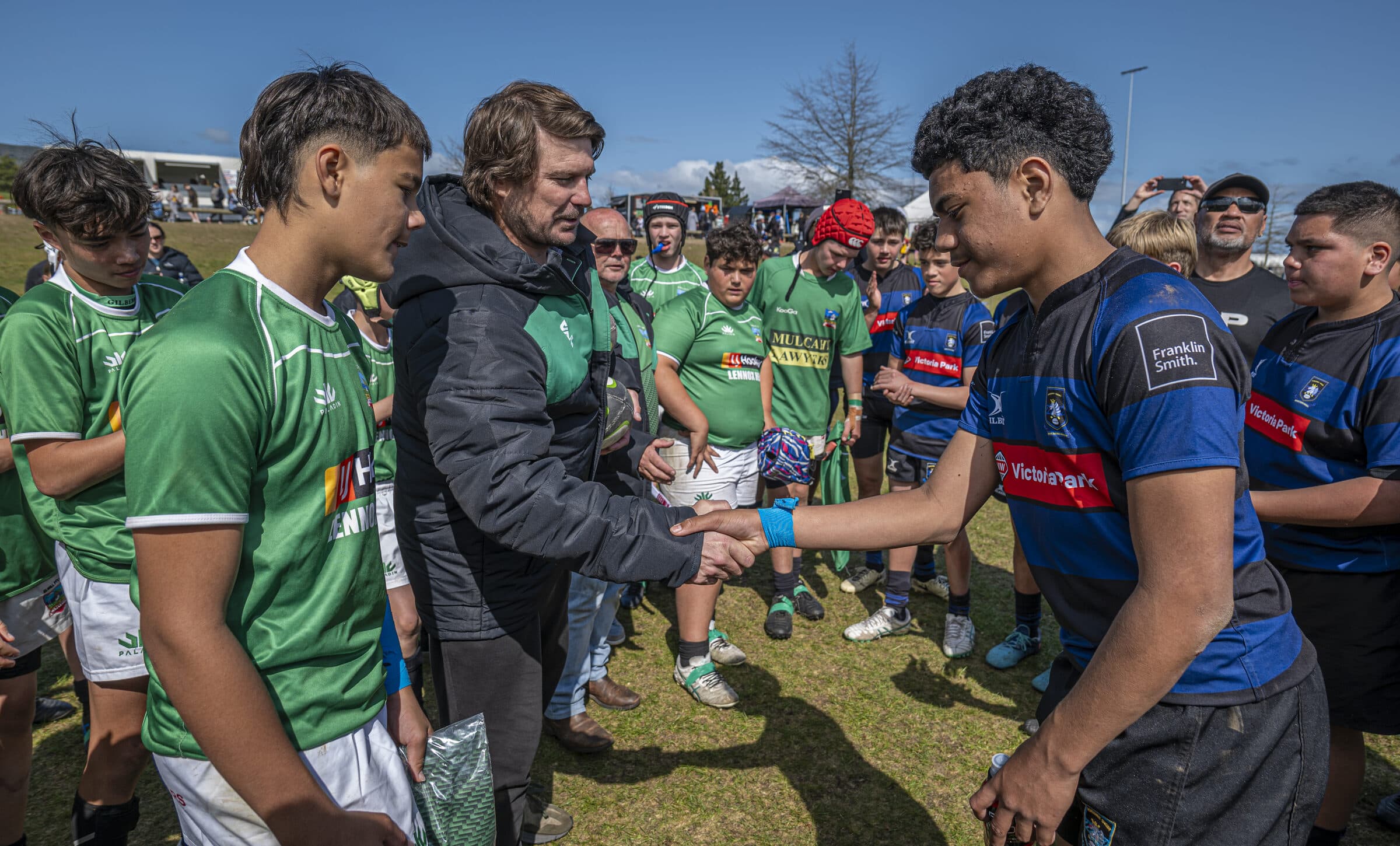 Players from opposing teams shaking hands and talking after a match