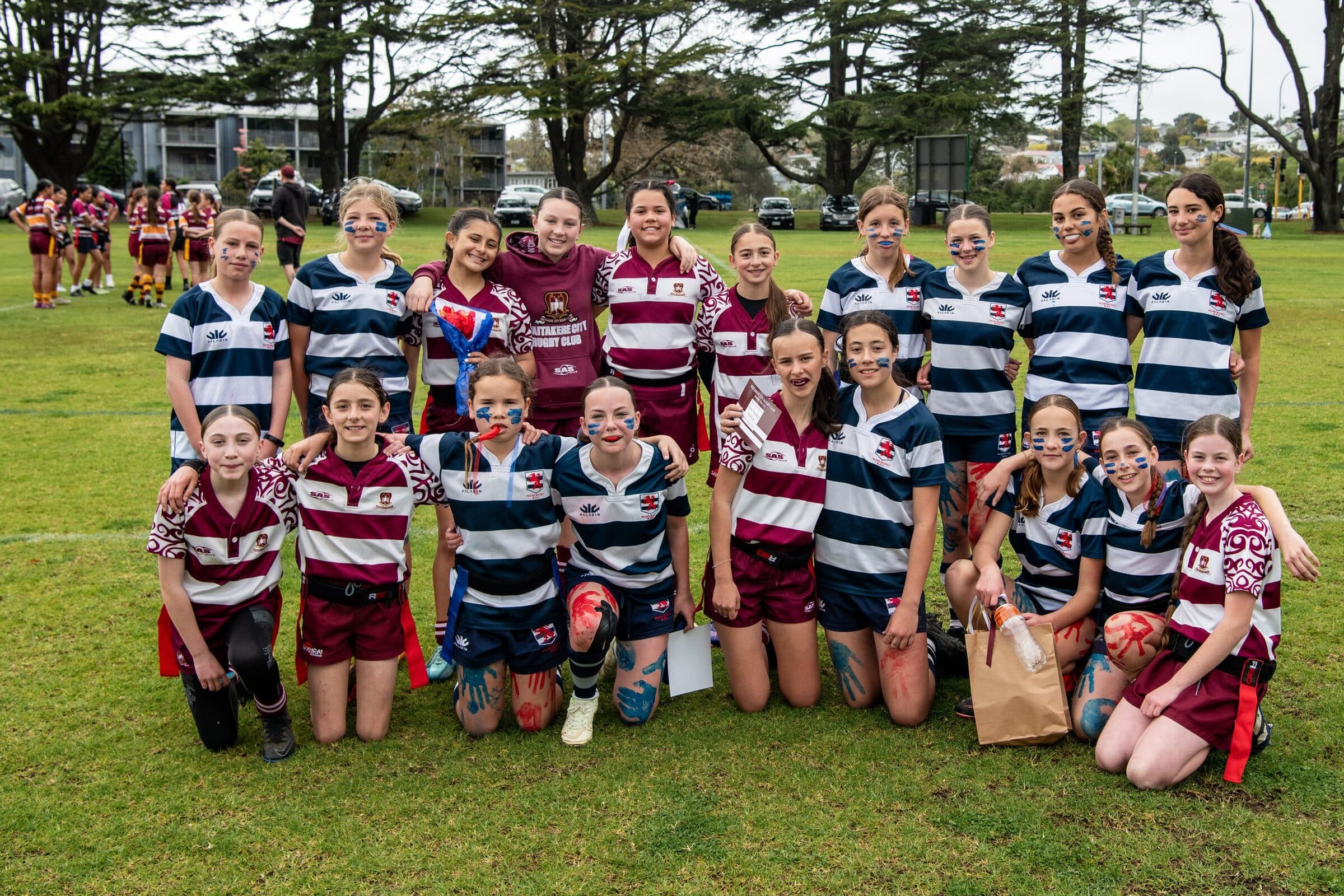A large group of girls' rugby teams gathered for a photo in their club strips