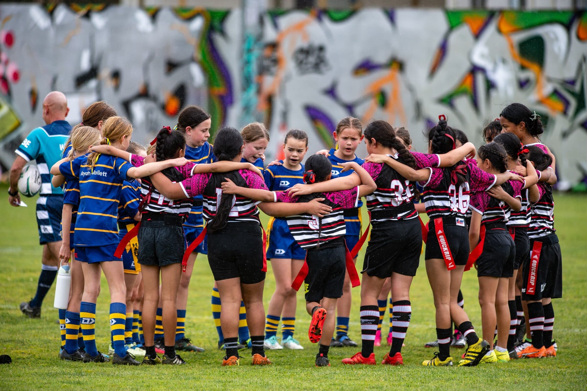 Two teams merged into one shoulder-to-shoulder huddle at a Global Games event