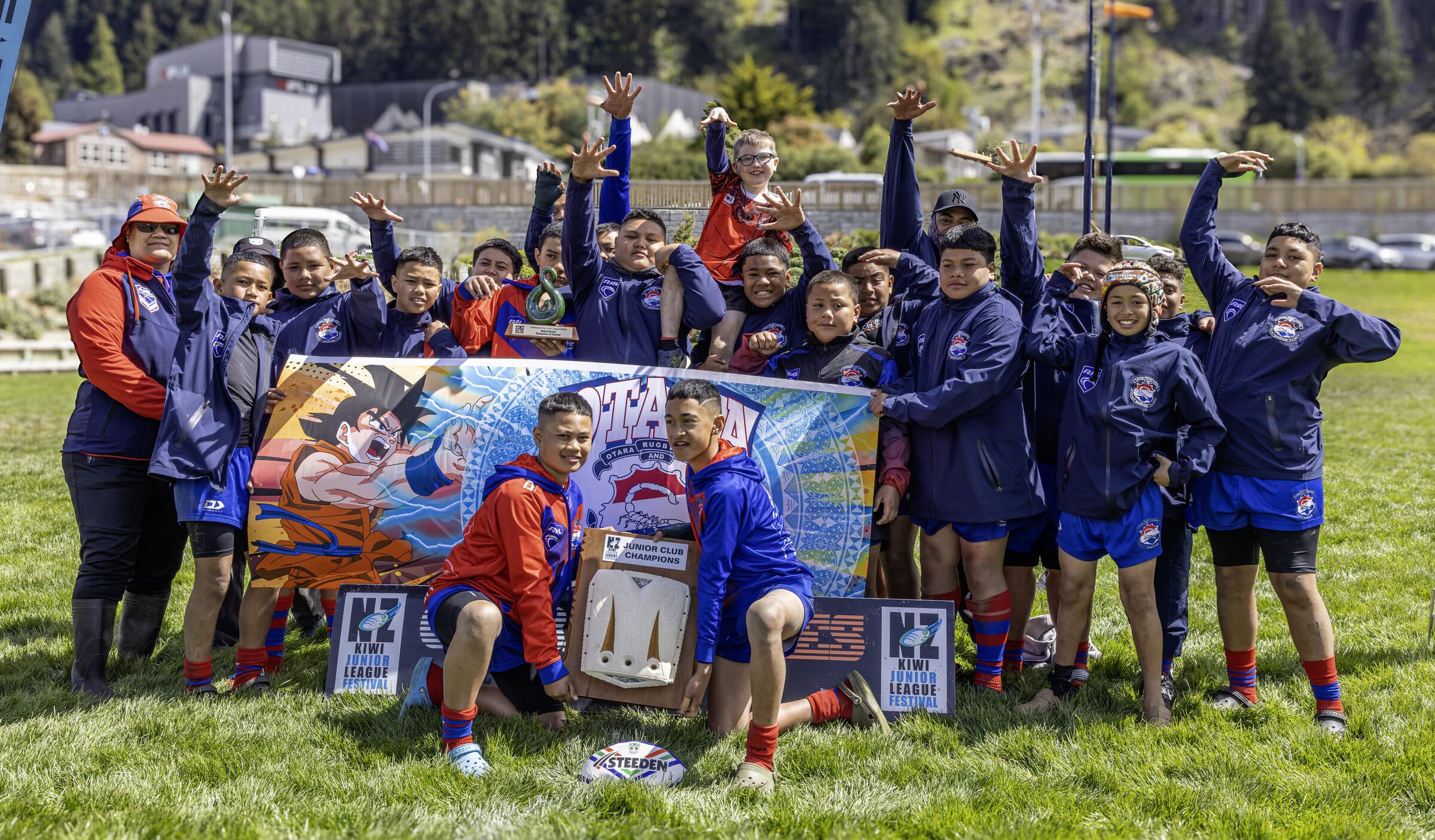 A team celebrating with arms raised behind their team banner